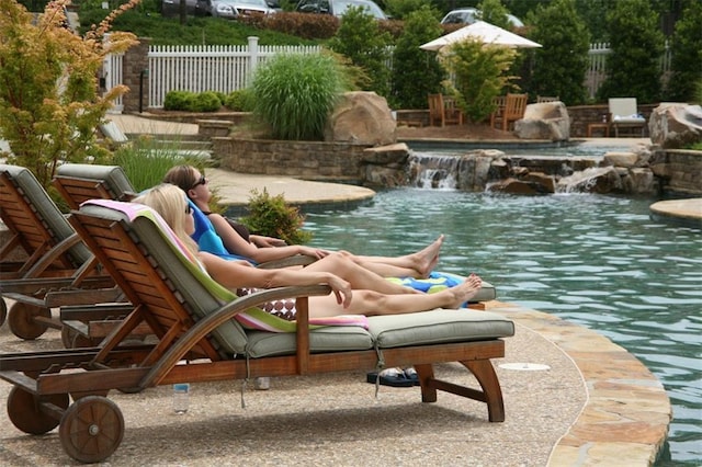 view of pool featuring pool water feature and a patio