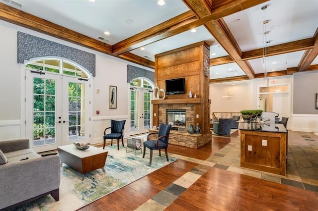 living room featuring french doors, a fireplace, hardwood / wood-style floors, and beam ceiling