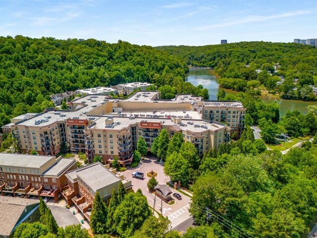 drone / aerial view featuring a water view and a view of trees