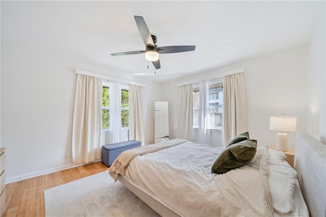 bedroom featuring baseboards, a ceiling fan, and wood finished floors