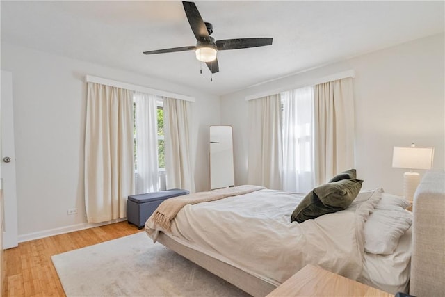 bedroom with baseboards, ceiling fan, and wood finished floors