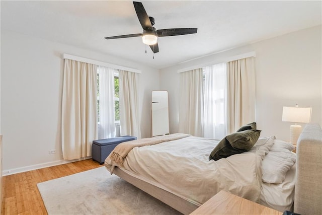 bedroom featuring baseboards, ceiling fan, and wood finished floors