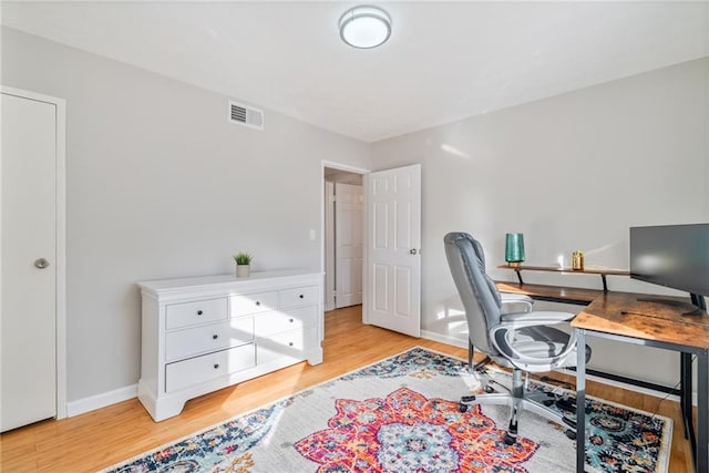 home office featuring baseboards, wood finished floors, and visible vents