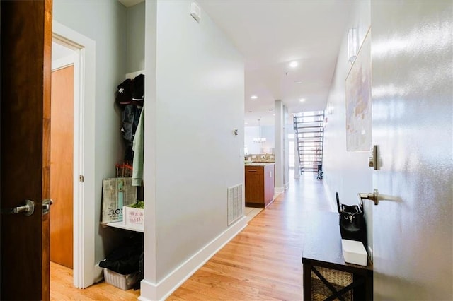 hall with recessed lighting, baseboards, visible vents, and light wood finished floors