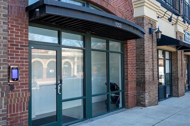 doorway to property with brick siding