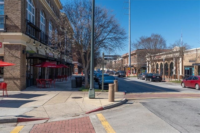 view of street featuring sidewalks, street lights, and curbs
