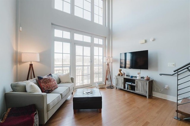1253 Caroline St NE, Atlanta, GA 30307 - living room featuring a towering ceiling, wood finished floors, baseboards, and stairway