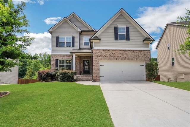 craftsman-style home with a front yard, fence, brick siding, an attached garage, and driveway
