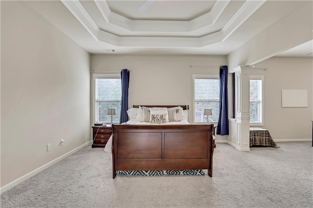 carpeted bedroom featuring baseboards, multiple windows, a tray ceiling, and crown molding