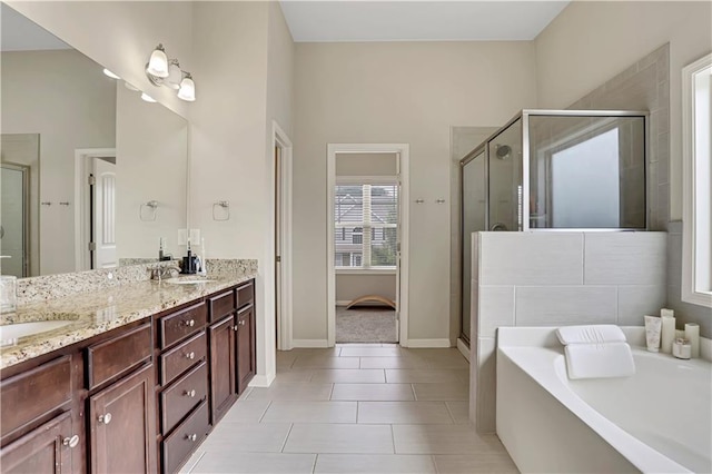 full bathroom featuring double vanity, a garden tub, a sink, and a stall shower