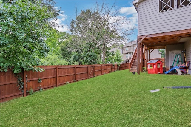 view of yard with a fenced backyard and stairway