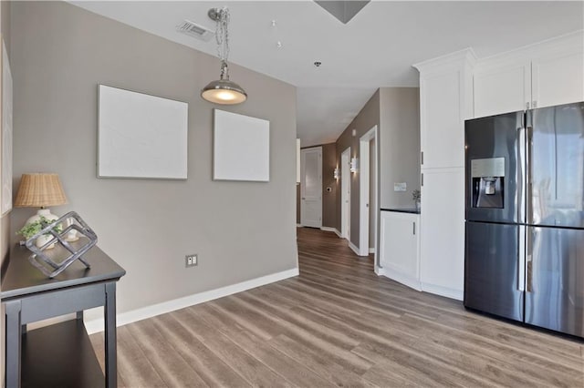 855 Peachtree St NE Unit 1703, Atlanta, GA 30308 - kitchen with stainless steel refrigerator with ice dispenser, light wood-style flooring, white cabinets, baseboards, and pendant lighting