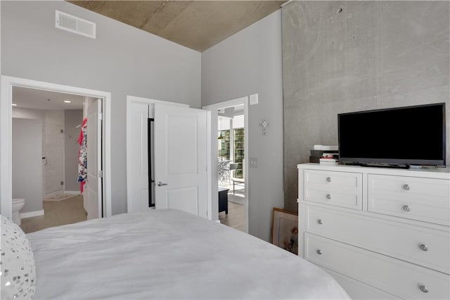 855 Peachtree St NE Unit 1703, Atlanta, GA 30308 - bedroom featuring light tile patterned floors, ensuite bathroom, a high ceiling, and baseboards