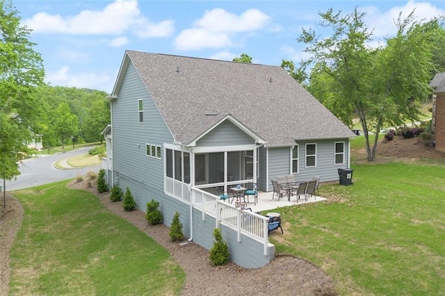 rear view of house with a patio, a yard, and a sunroom