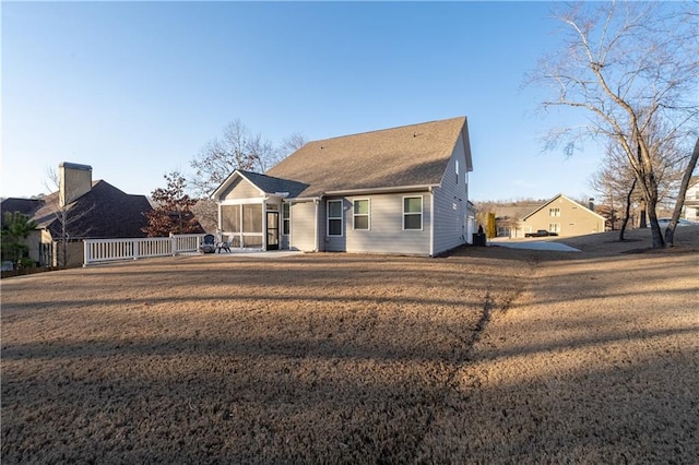 view of front of property featuring a sunroom and a front lawn