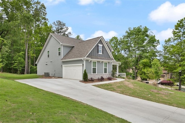 craftsman house with cooling unit, a garage, and a front yard