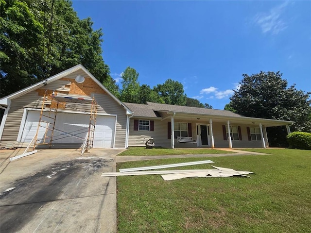 view of front of home with a garage, driveway, a front yard, and covered porch