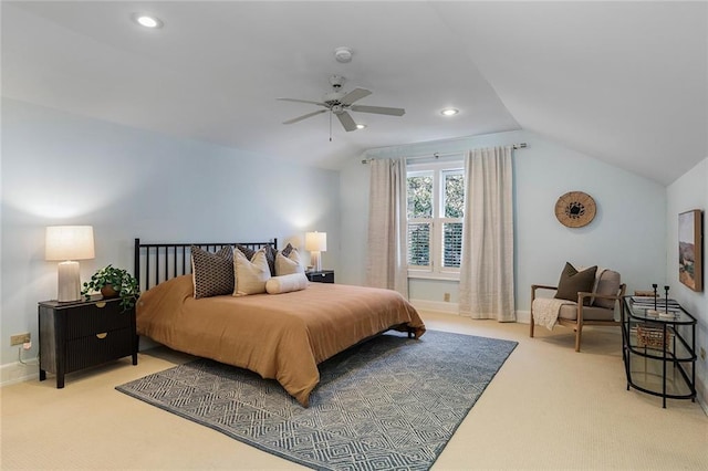 bedroom with ceiling fan, vaulted ceiling, and light colored carpet