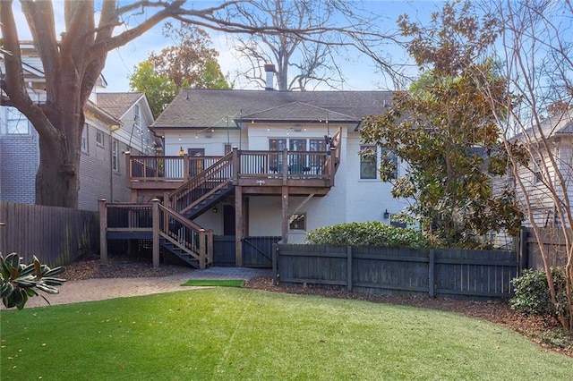 back of house featuring a lawn and a wooden deck