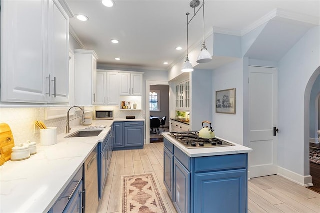 kitchen featuring crown molding, white cabinetry, blue cabinets, appliances with stainless steel finishes, and sink