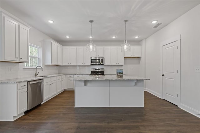 kitchen featuring visible vents, appliances with stainless steel finishes, backsplash, and white cabinets