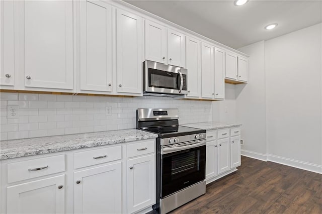 kitchen with baseboards, white cabinets, stainless steel appliances, and dark wood finished floors