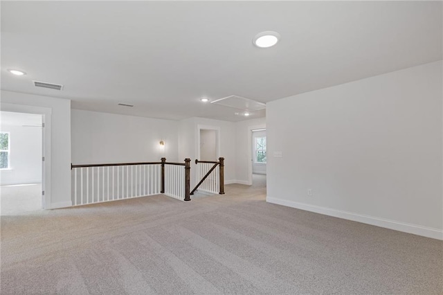 unfurnished room with recessed lighting, baseboards, light colored carpet, and attic access