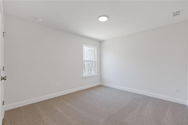 empty room featuring carpet flooring, baseboards, and visible vents