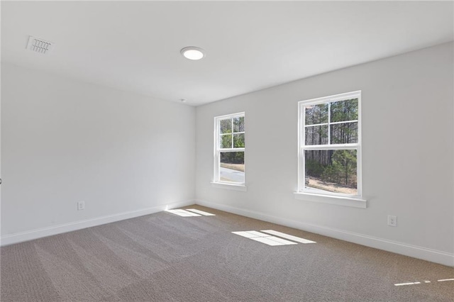 carpeted empty room with visible vents and baseboards