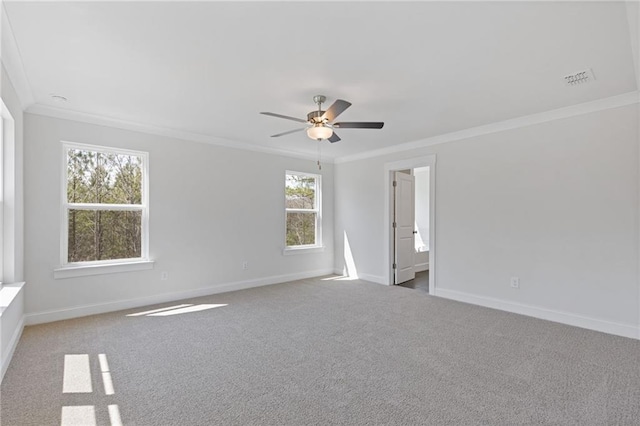 spare room featuring ceiling fan, ornamental molding, baseboards, and carpet