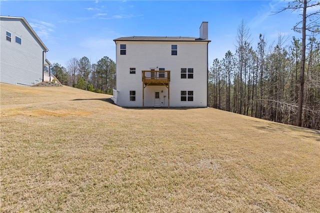 back of property featuring a lawn, a wooden deck, and a chimney