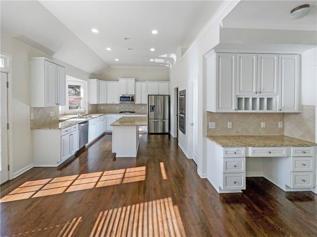 kitchen with light stone counters, stainless steel appliances, a kitchen island, white cabinetry, and open shelves