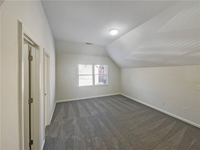 bonus room featuring lofted ceiling, baseboards, and dark colored carpet