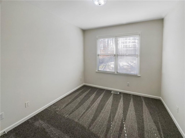 carpeted spare room featuring visible vents and baseboards