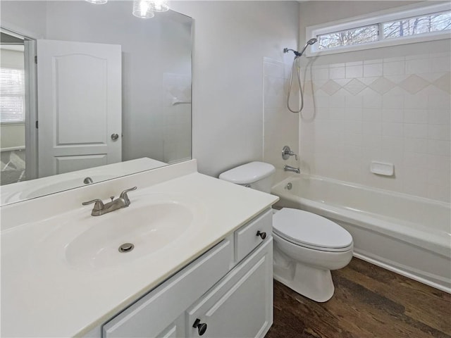 full bath with toilet, bathtub / shower combination, wood finished floors, and vanity