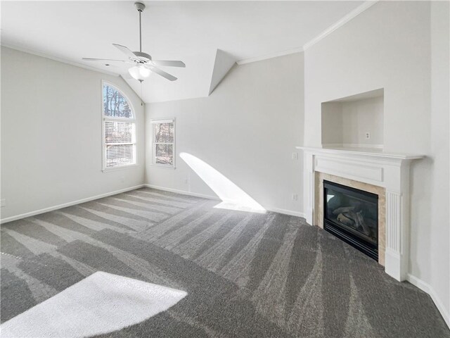 unfurnished living room with dark colored carpet, ornamental molding, a glass covered fireplace, and baseboards