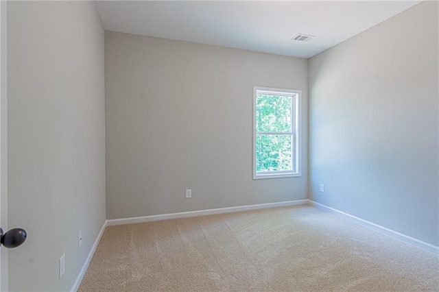 unfurnished room with baseboards, visible vents, and light carpet