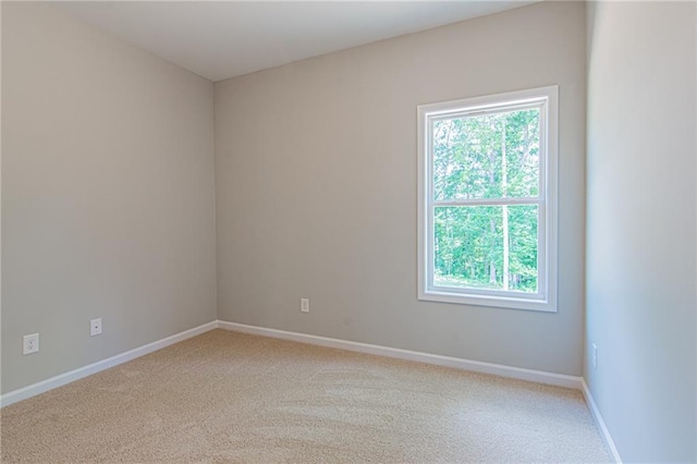 empty room with light colored carpet and baseboards