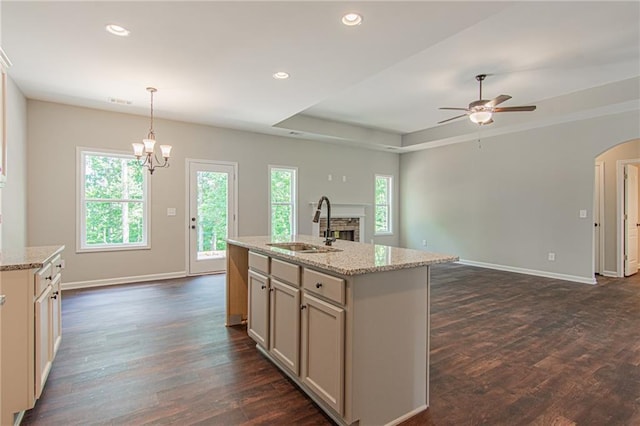 kitchen featuring open floor plan, ceiling fan with notable chandelier, plenty of natural light, and a sink