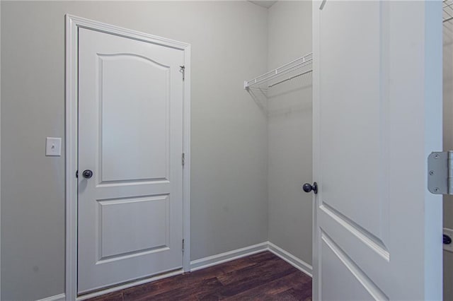 washroom featuring laundry area, baseboards, and dark wood-style flooring