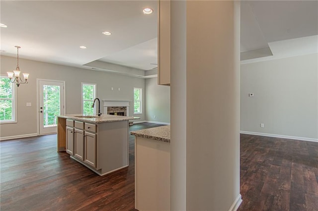 kitchen with a sink, a tray ceiling, a wealth of natural light, and open floor plan