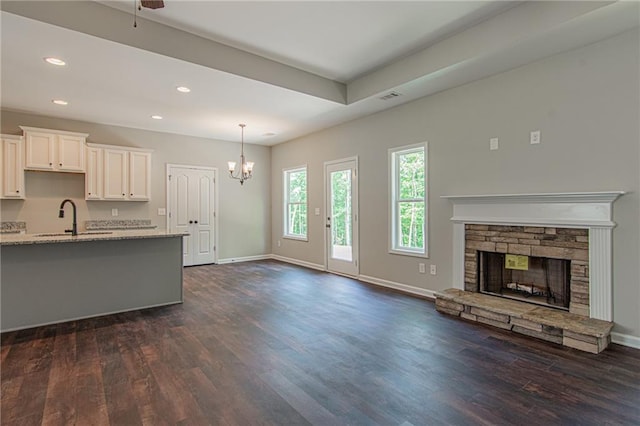 kitchen featuring dark wood-style floors, a notable chandelier, open floor plan, and a sink