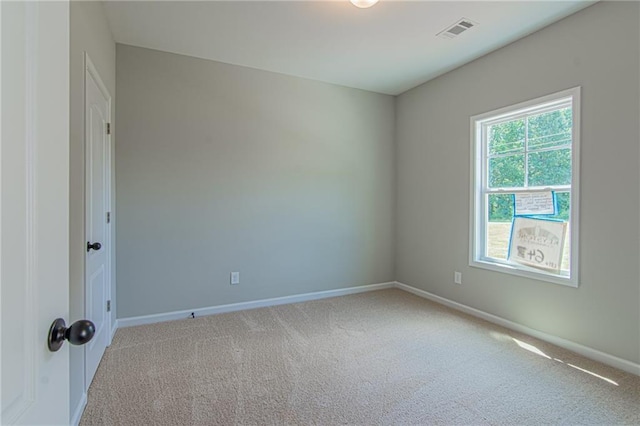 unfurnished room featuring carpet, visible vents, and baseboards