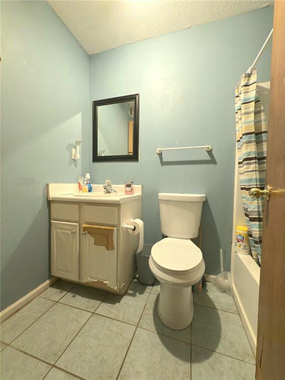 bathroom with vanity, tile patterned floors, toilet, and baseboards