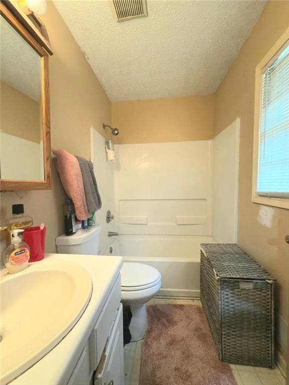 bathroom featuring visible vents, toilet, a textured ceiling, shower / washtub combination, and vanity