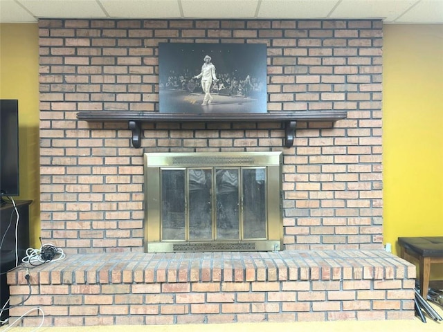 interior details featuring a paneled ceiling and a fireplace