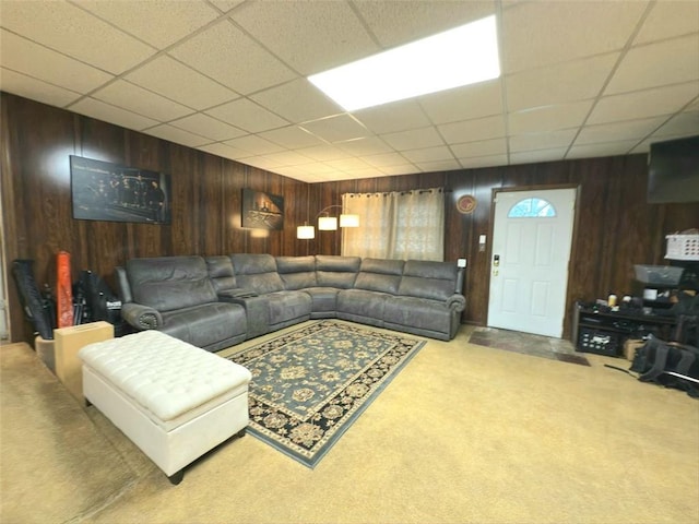 living area with carpet flooring, wood walls, and a paneled ceiling