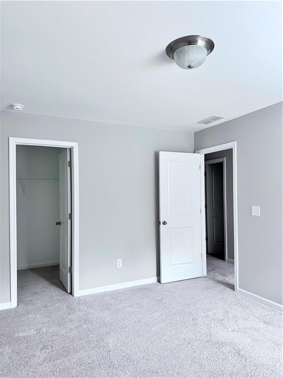 unfurnished bedroom featuring light carpet and a closet