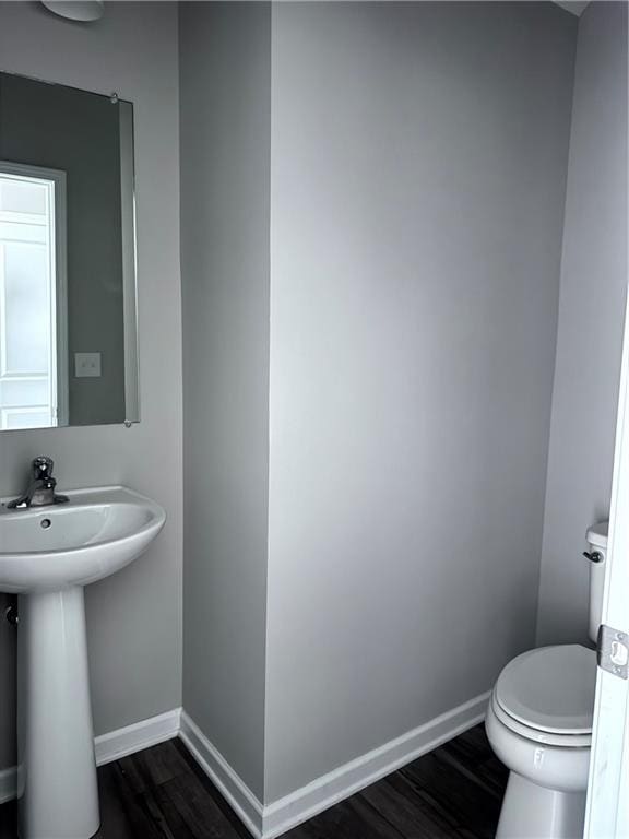 bathroom featuring wood-type flooring, toilet, and sink