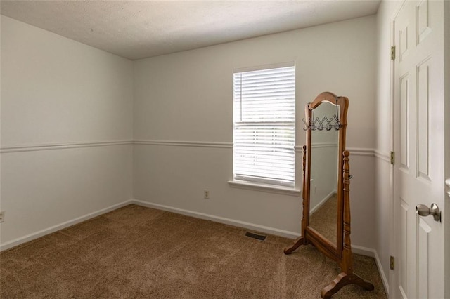 carpeted spare room with baseboards and visible vents